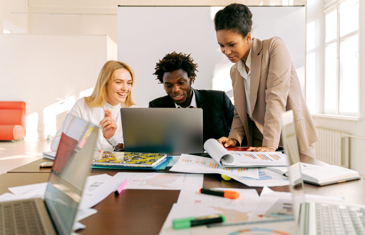 Creative team collaborating around a laptop